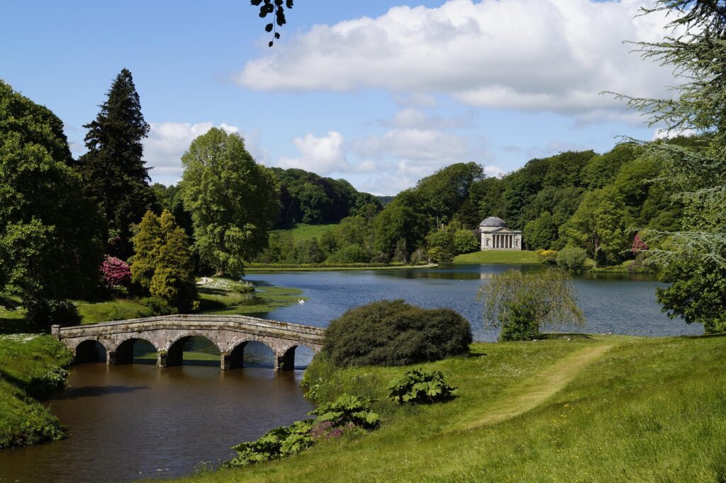 On many estates, the English landscape garden replaced the symmetrical Baroque gardens (Stourhead, photo by Sabine Buchenau on Pixabay)